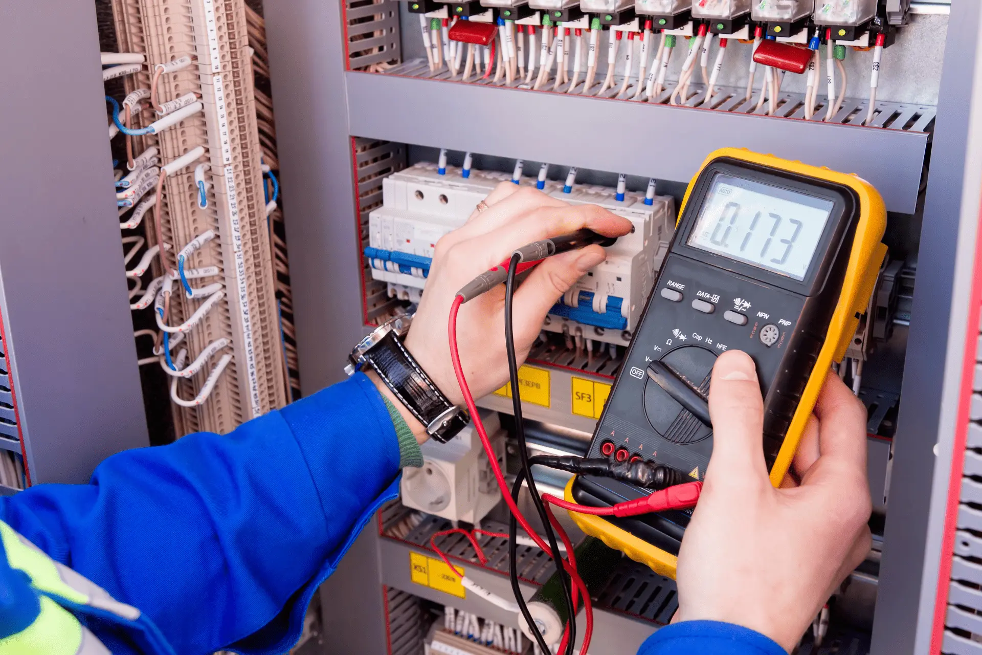 Electrician checking an electrical panel with a multimeter